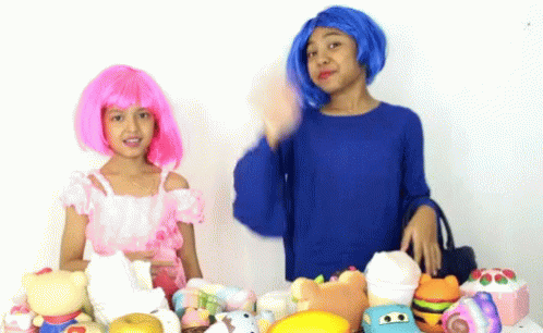 two women with orange hair, blue skin and orange hair are standing near an assortment of toys
