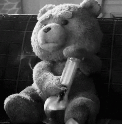 black and white po of a teddy bear sitting on a couch