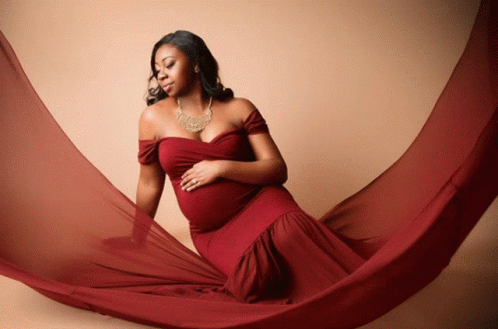 a pregnant woman is wrapped in a blue piece of cloth