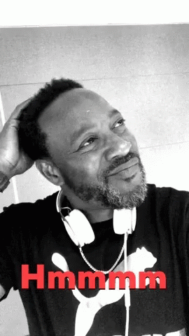 a black man wearing headphones sitting in front of a mirror