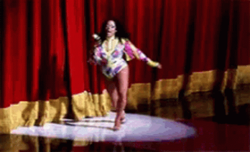 a woman in an elaborate outfit and shoes dancing on a stage