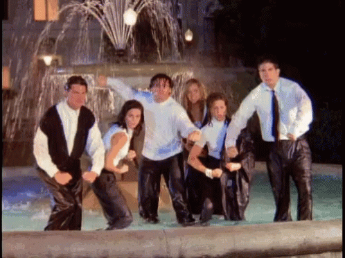 group of people pose in front of water fountain