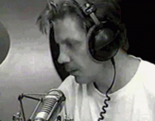 a man holding a microphone and talking on the phone