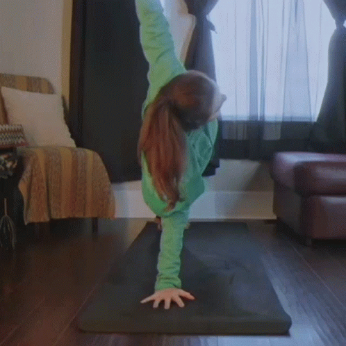 a woman is doing handstand in a living room