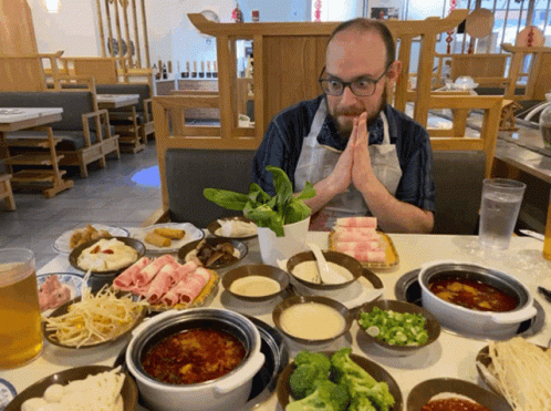 a man standing in front of a table filled with plates of food
