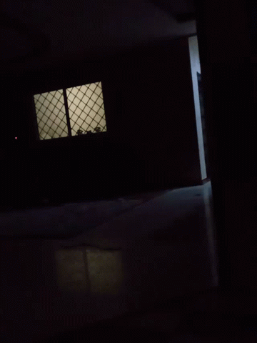 a dark room with only a window and light coming in