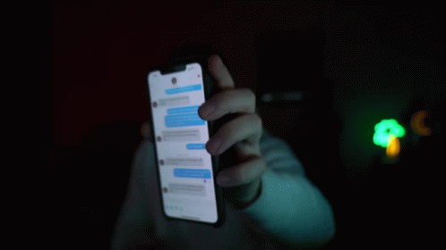 person holding up a smartphone with a glowing screen