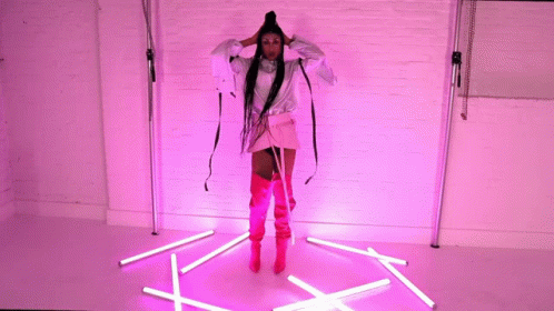 a woman standing in the middle of a room with white sticks on the floor