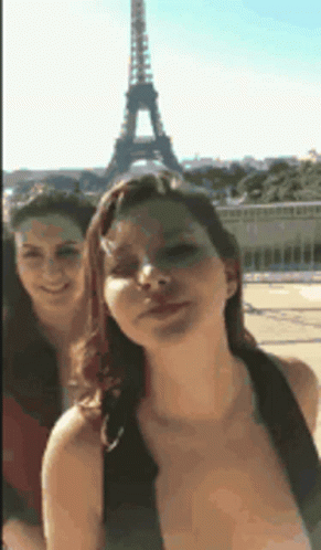two girls standing in front of the eiffel tower