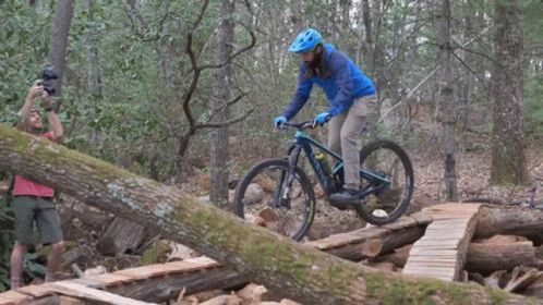 a man is doing a trick on a bike in the forest