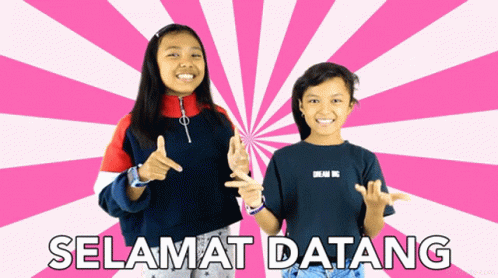 two girls holding soing up with the words, selamat datang