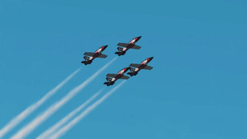 a group of jet fighter planes flying through a cloudy sky