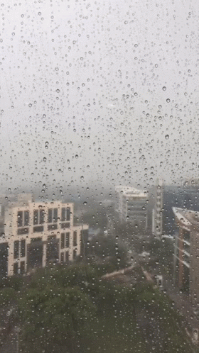 rain covered window with cityscape in the background