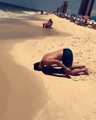 a man laying on top of a white sandy beach