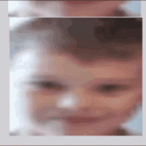 a baby is blurred into the camera and has blue eyes
