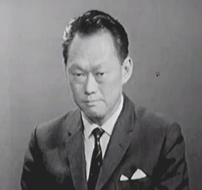 an asian man with a serious look wearing a suit
