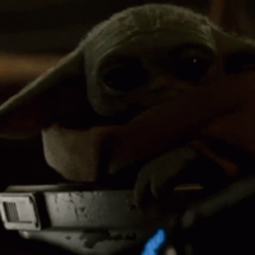 a baby yoda in a star wars costume with a phone