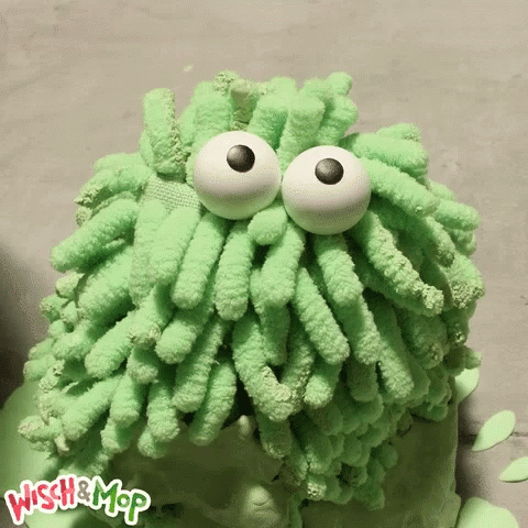 a green sponge with googly eyes on top of it
