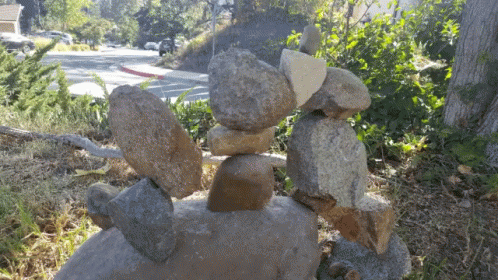 rocks stacked together in front of trees and some walkway
