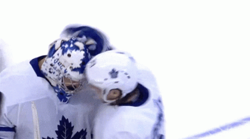 two hockey players walking on the ice hugging