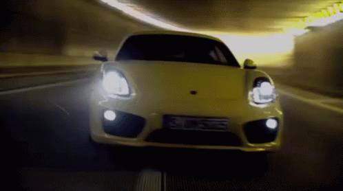a small sports car traveling through a tunnel at night