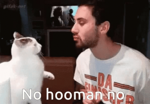 man standing next to white cat in room with nohoomanmer logo on t - shirt