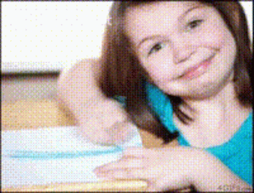 a smiling girl is in front of a computer screen