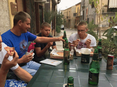 group of people sitting at a table eating and drinking
