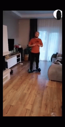 a man is riding on a skateboard in a living room