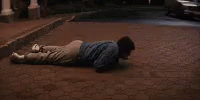 a man laying on the ground in front of a building