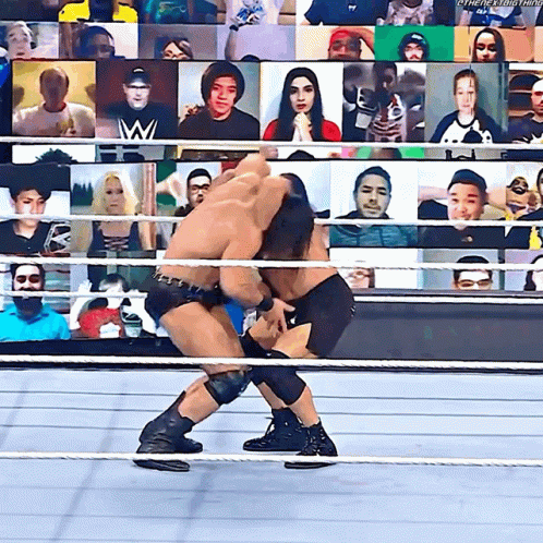 two wrestling wrestlers fighting in an audience