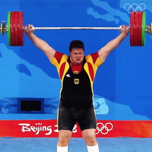 a man is doing a barbell squat exercise in front of an olympics sign
