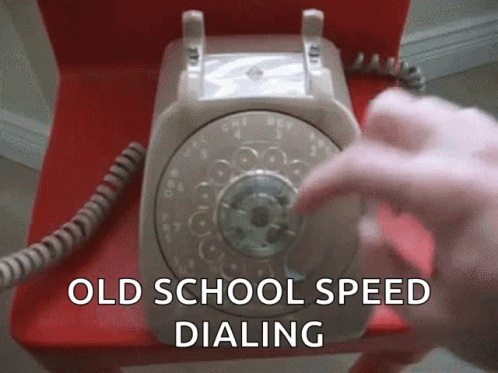 an old school speed dialing phone with hand using it