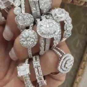 a person holding multiple rings made from diamonds