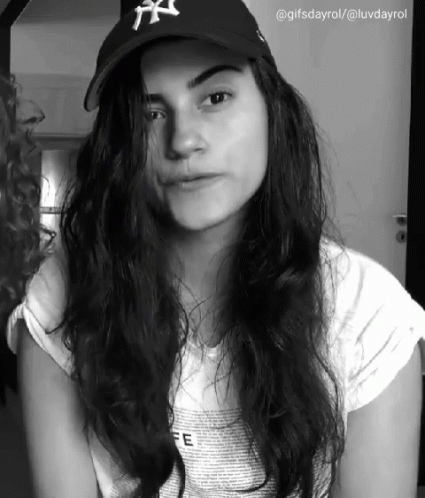 a person with long hair and a baseball hat
