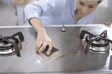 a woman with blue hair cleaning the kitchen counter