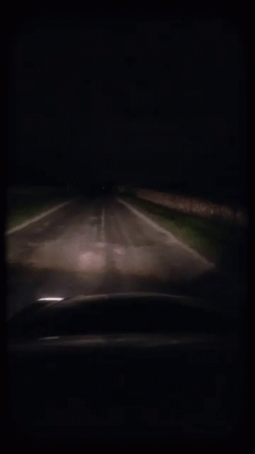 an eerie car driving along a dark road