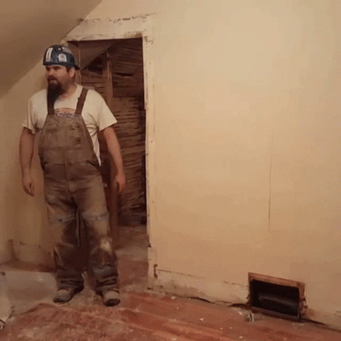 a man standing in a room with unfinished wall