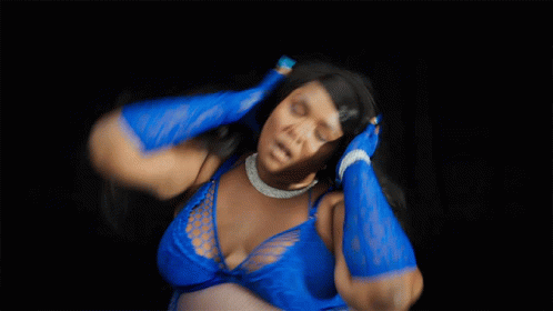 a woman with a blue body suit is dancing