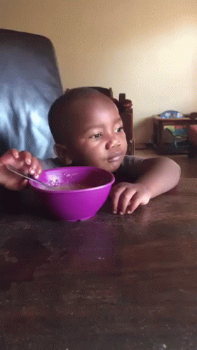 there is a baby with a purple bowl