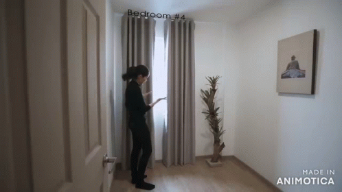 a person standing in the doorway of a room with curtains