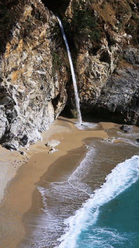a stream of water running from rocks into the ocean