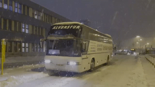 a city bus drives down a snowy street