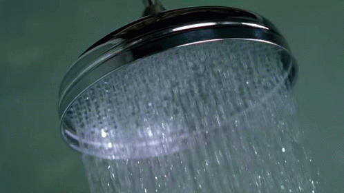 a closeup of a shower head with lots of water running off it