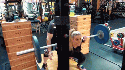 a woman lifting a bar in a gym