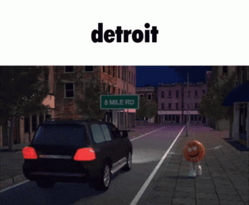 two cars parked on the street near a sign that reads detroit