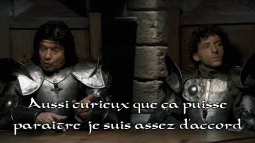 two knights in armor are talking and one has his fingers crossed