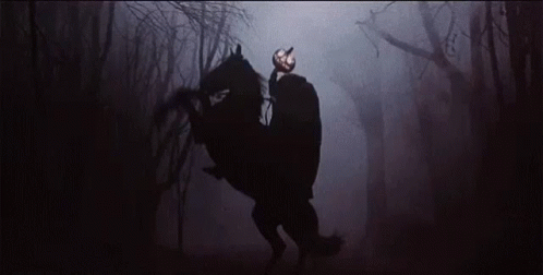 the person with the horse is walking through the dark woods