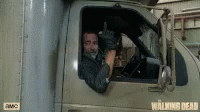 man waving from behind the wheel of a moving truck
