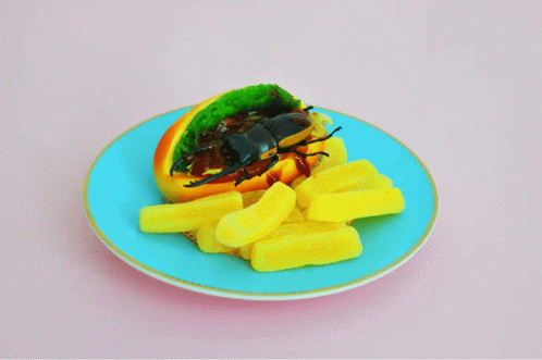 a plate topped with blue food with a bug sitting on it